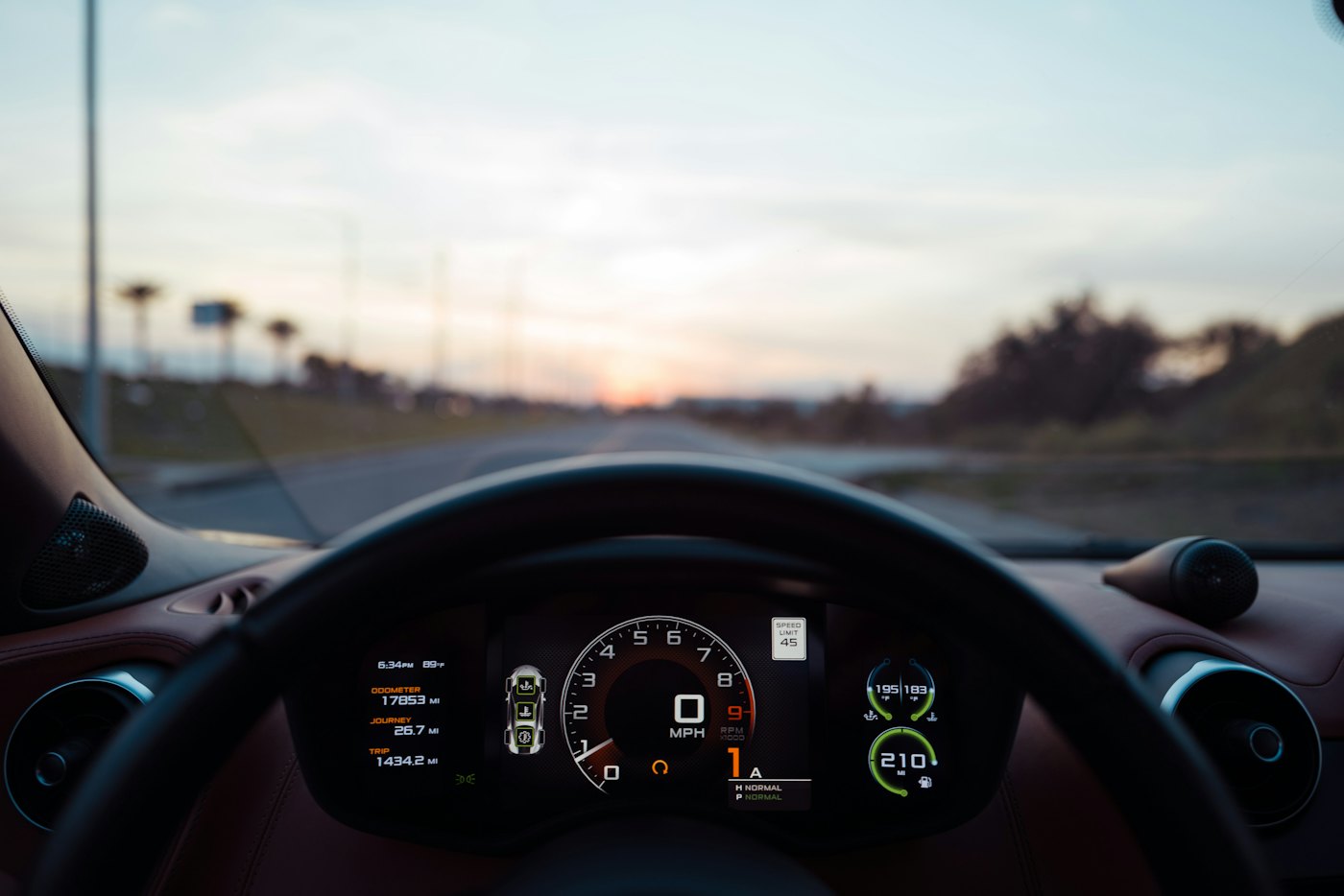 A car instrument cluster lit at night, odometer and gauges in close-up