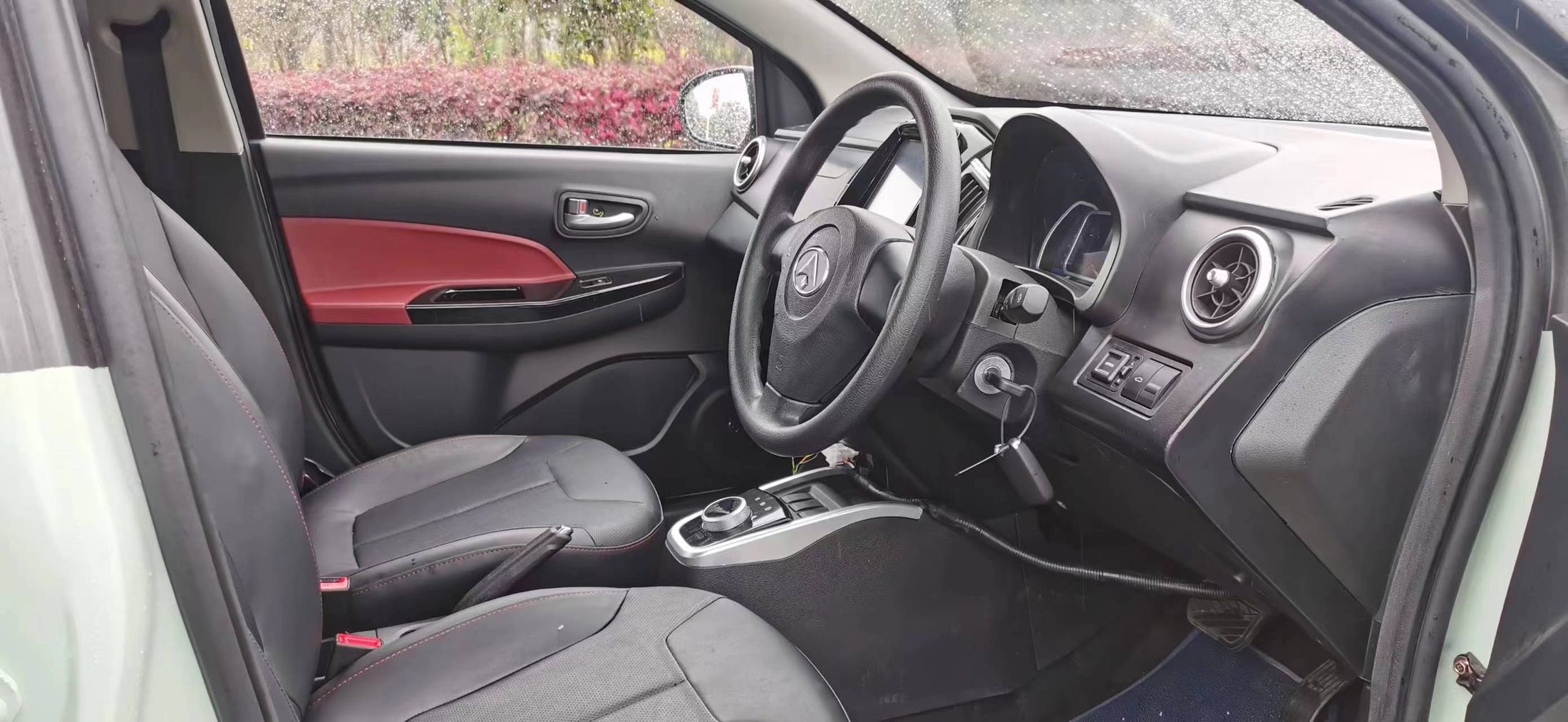 The D01's dashboard, steering wheel and rotary selector seen through the open driver's door