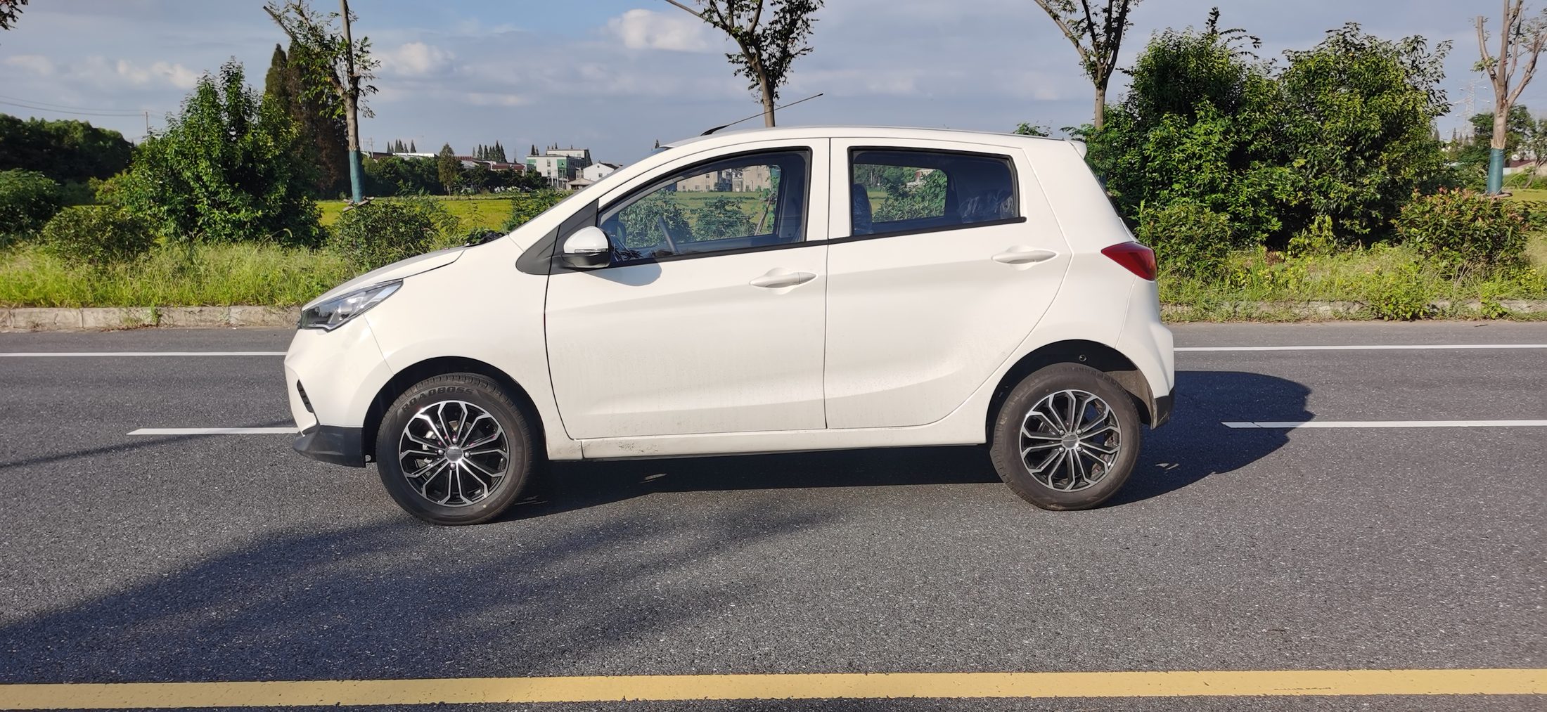 A white Kaifeng D01 square on from the side, parked at the kerb