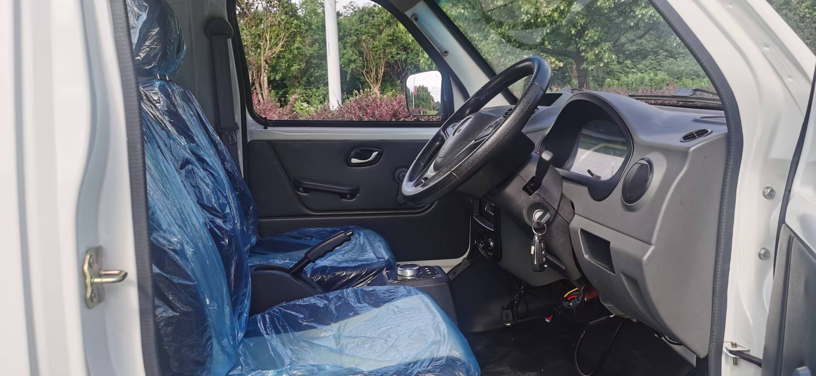 The KF1 EV's cab seen through the open driver's door